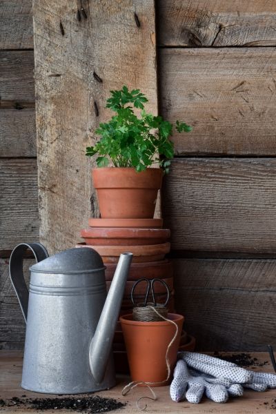 a stack of terracotta pots and a watering can